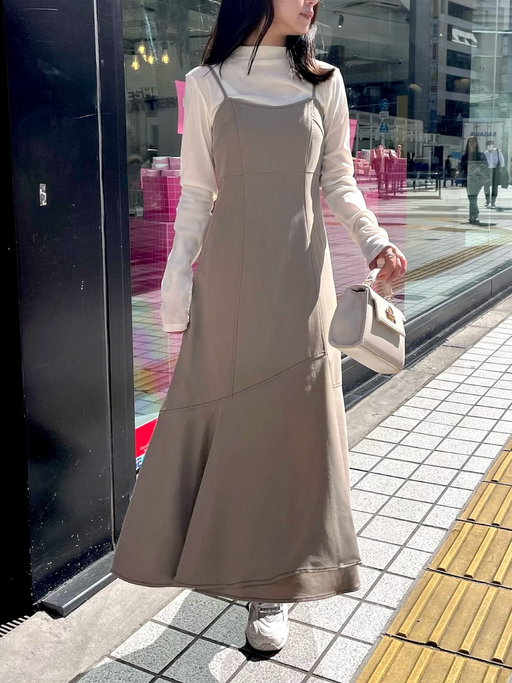 ブラウン系のワンピース、ホワイト系のTシャツ/カットソー、ホワイト系のライダースジャケットを着用したレディースの秋コーディネートの4枚目の写真