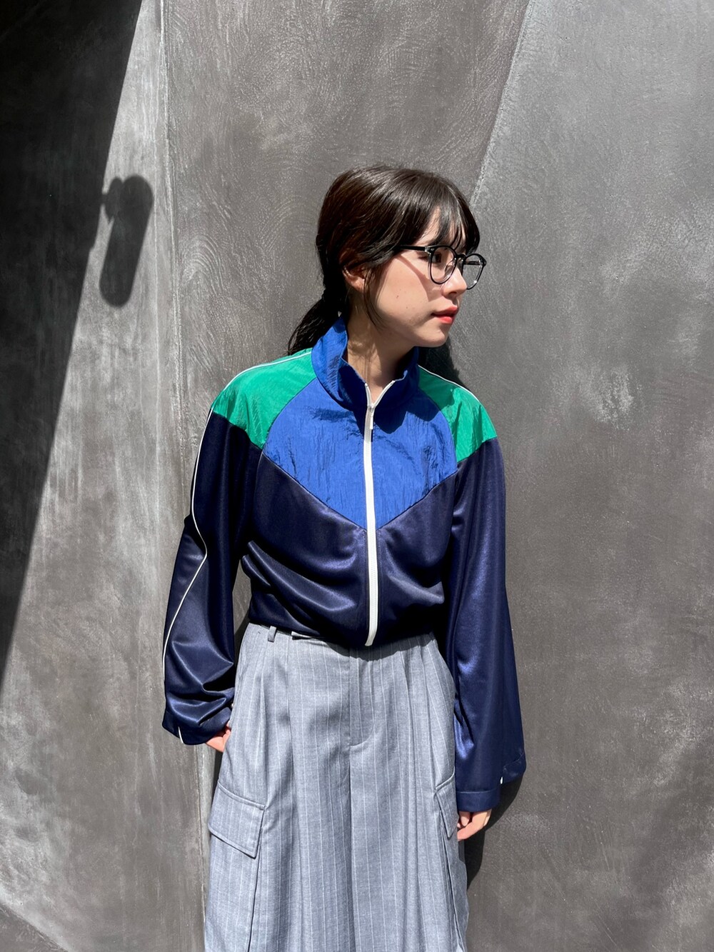 ブルー系のナイロンジャケット、グレー系のスラックスを着用したレディースの秋コーディネートの4枚目の写真