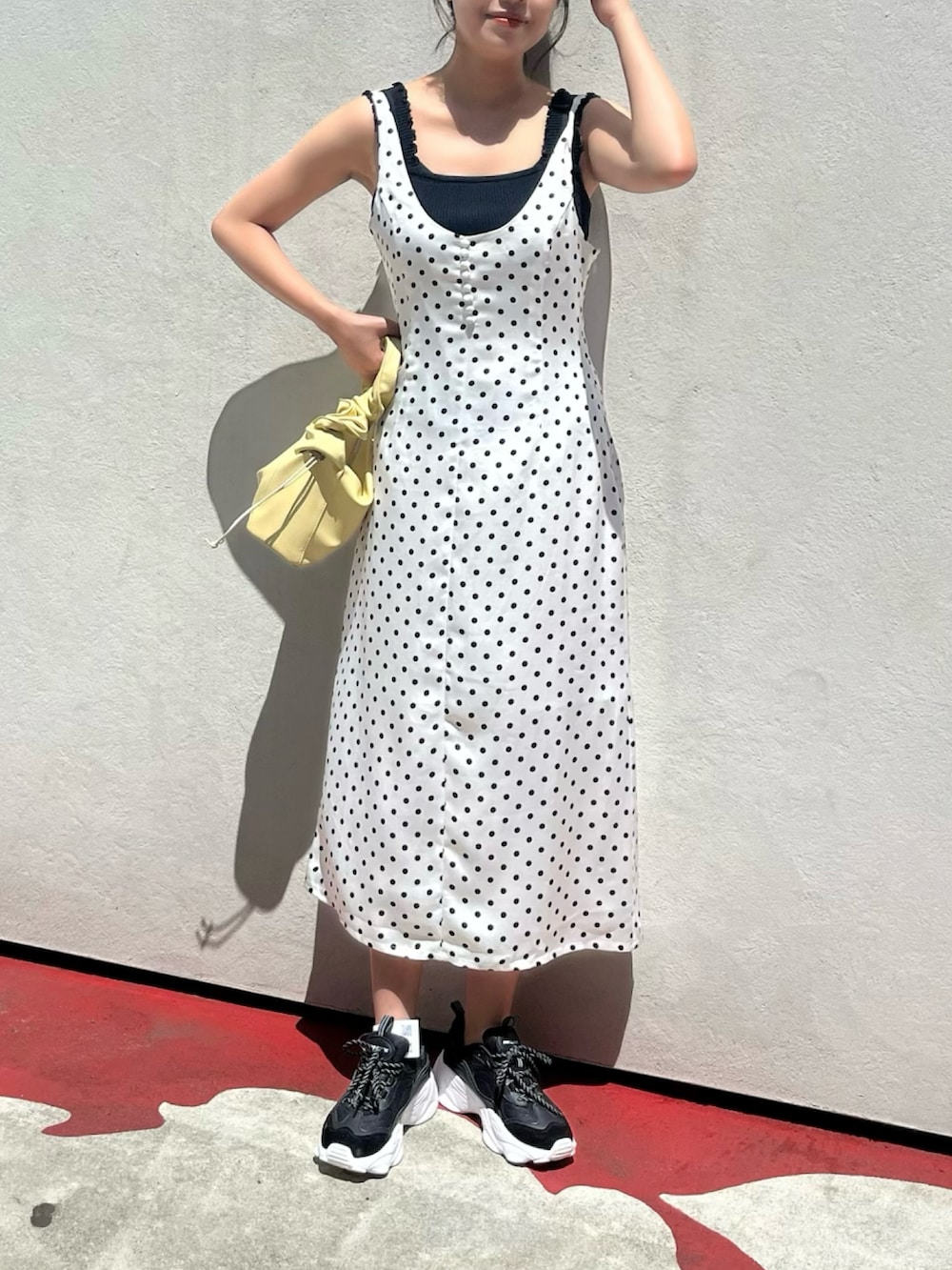 ホワイト系のワンピース、ブラック系のニット/セーター、イエロー系のトートバッグを着用したレディースの夏コーディネートの4枚目の写真