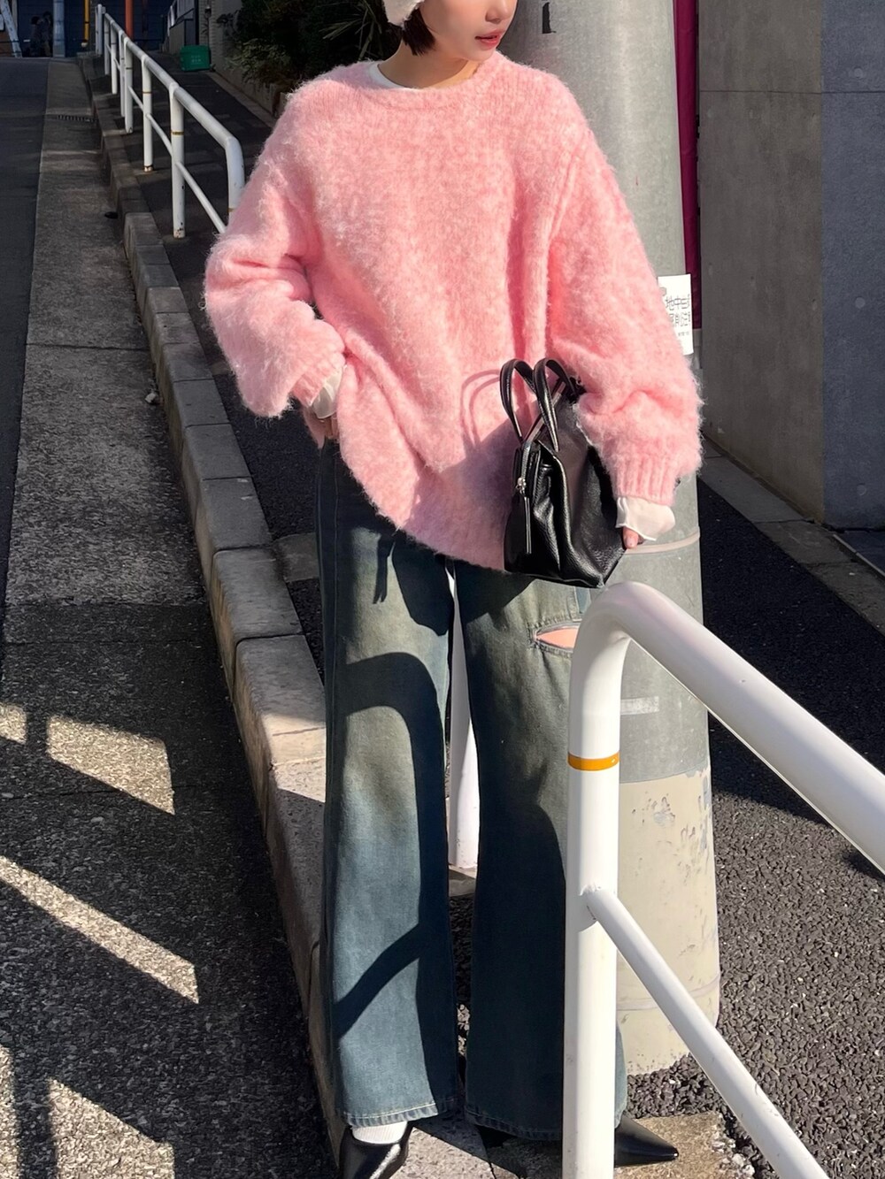 ピンク系のニット/セーター、ホワイト系のTシャツ/カットソー、ブルー系のデニムパンツを着用したレディースの冬コーディネートの2枚目の写真