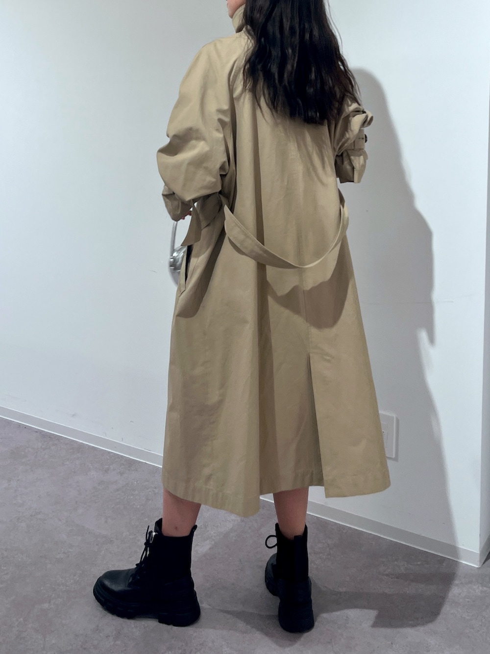 ベージュ系のトレンチコート、グリーン系のスカートを着用したレディースの春コーディネートの3枚目の写真