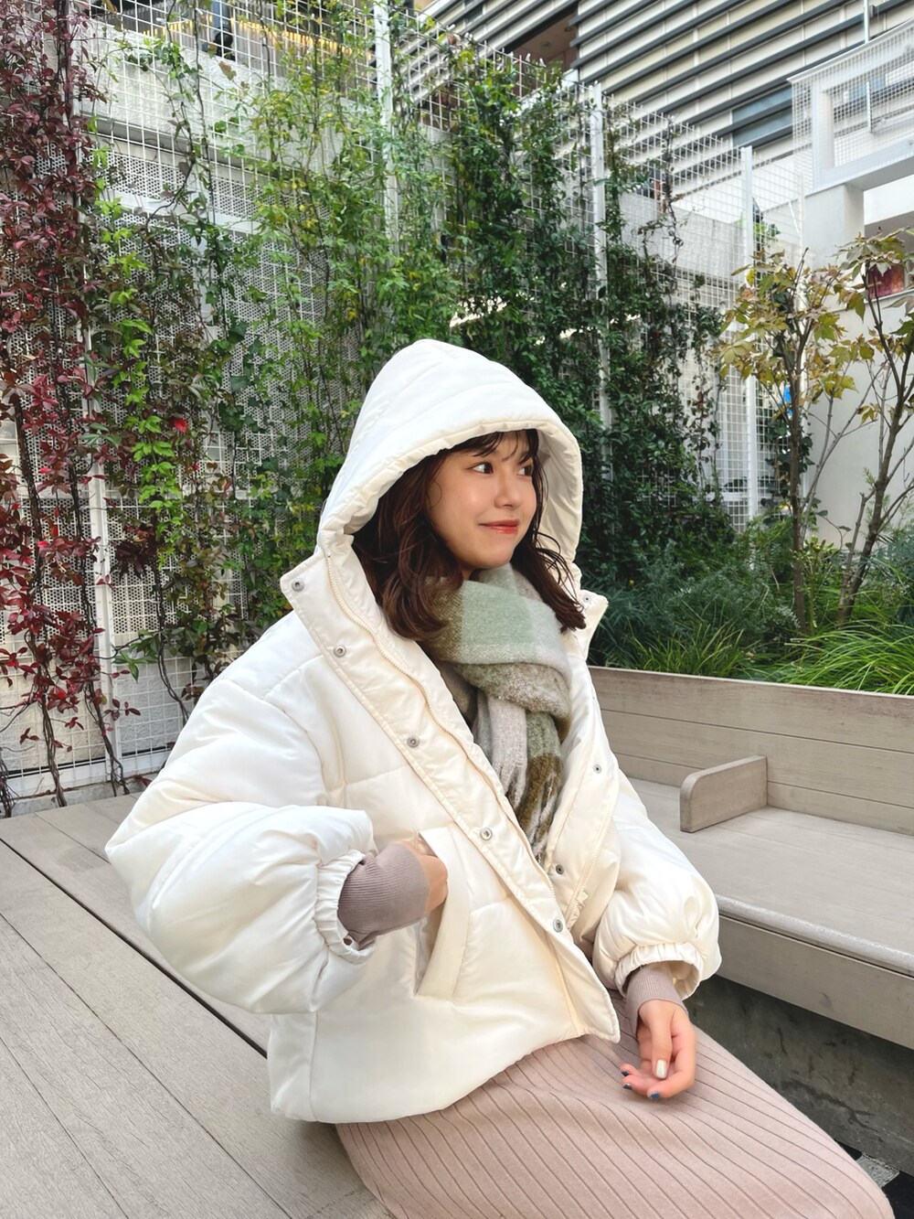 ホワイト系のブルゾン、ベージュ系のワンピース、グリーン系のストール/ショールを着用したレディースの冬コーディネートの2枚目の写真