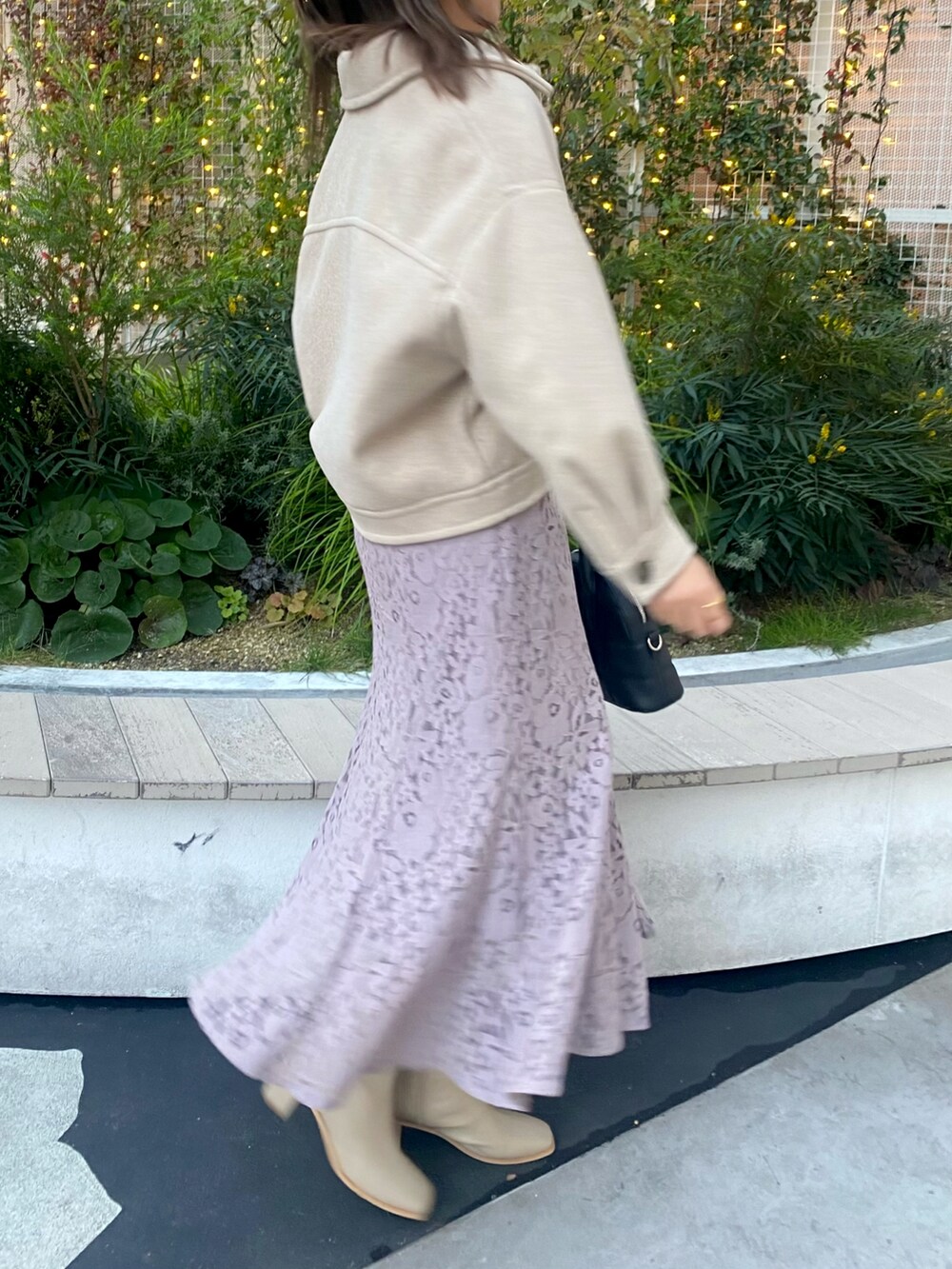 ブラウン系のブルゾン、ブラック系のショルダーバッグ、パープル系のスカートを着用したレディースの冬コーディネートの2枚目の写真