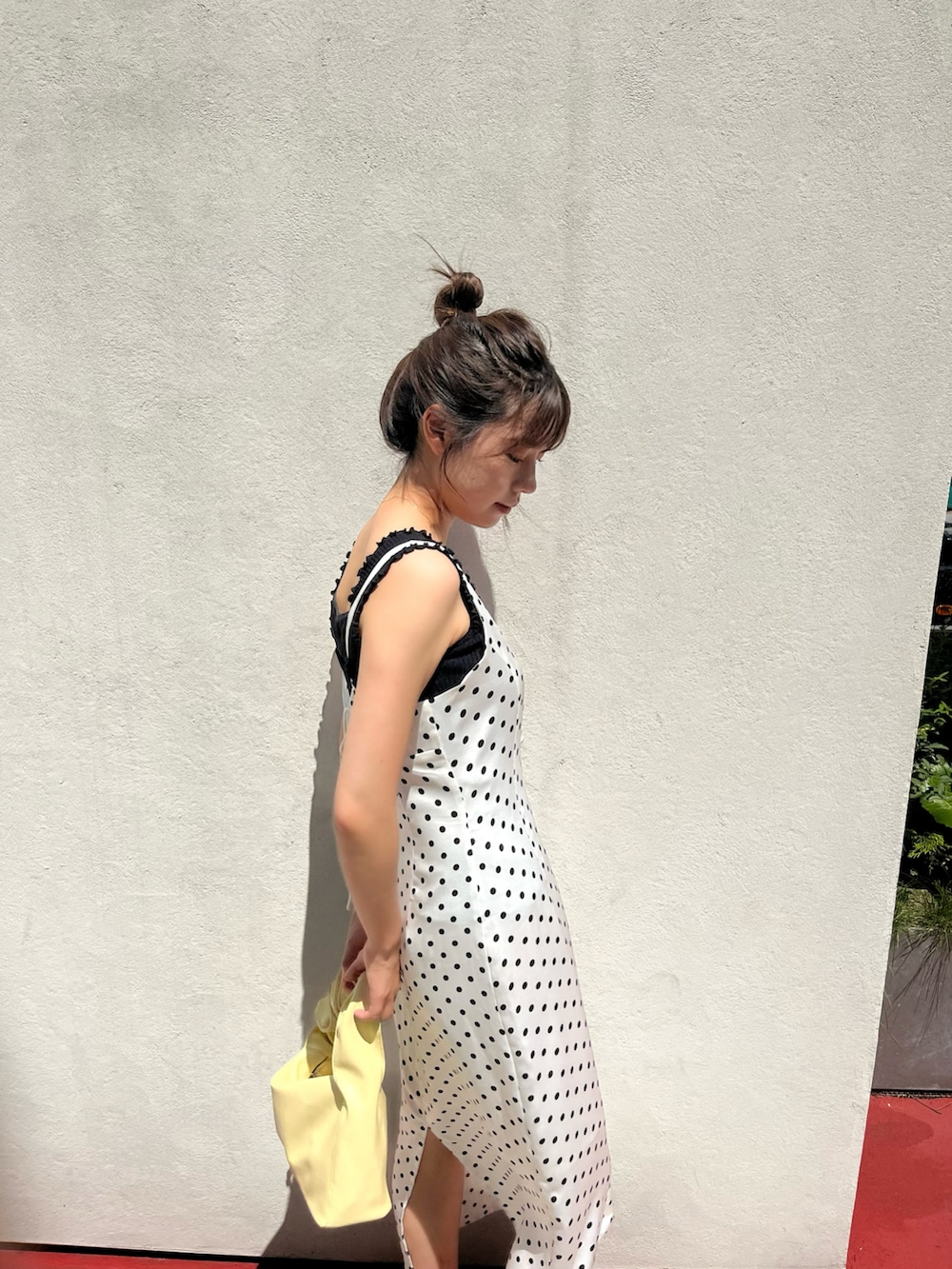 ホワイト系のワンピース、ブラック系のニット/セーター、イエロー系のトートバッグを着用したレディースの夏コーディネートの2枚目の写真