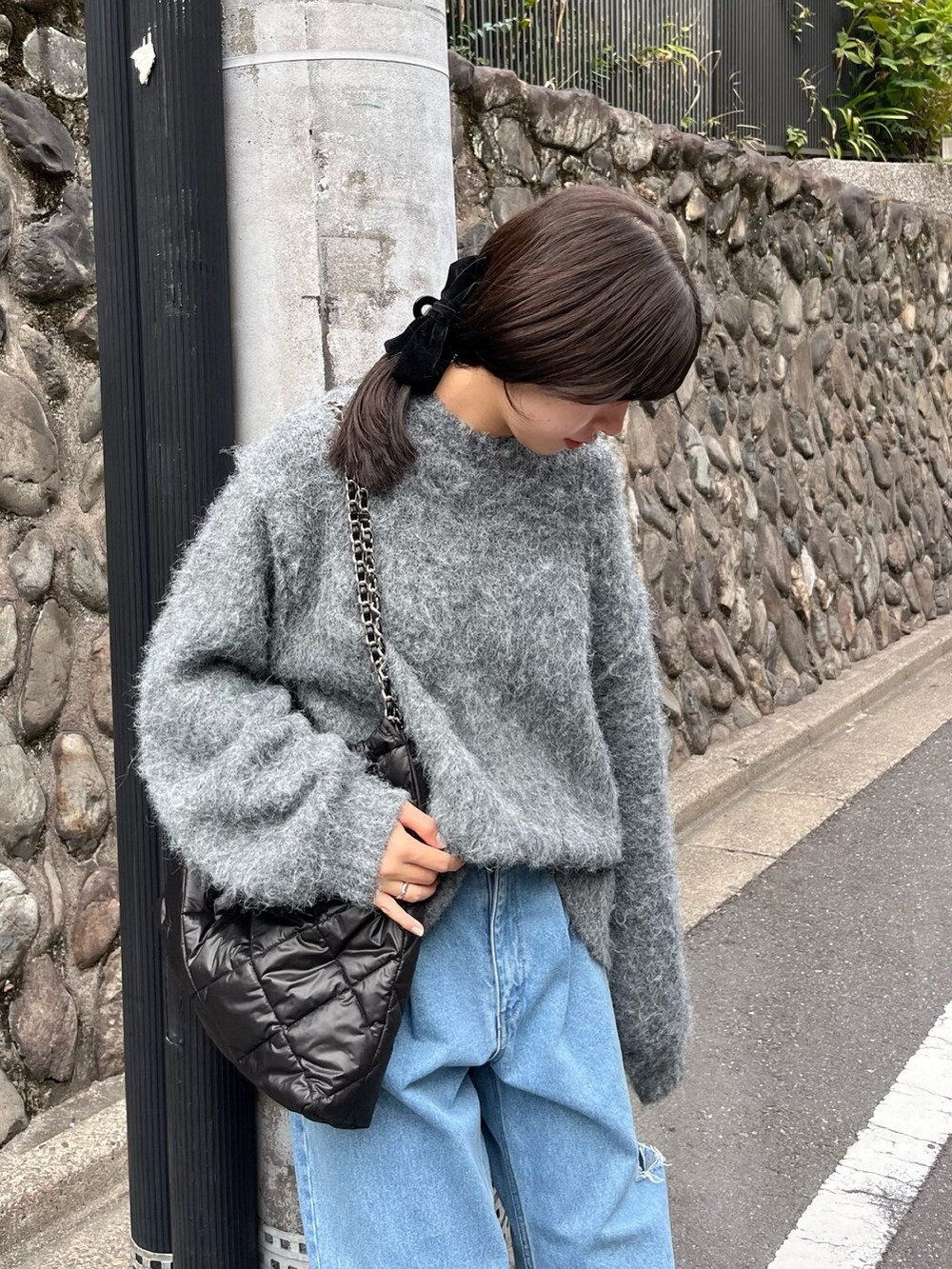 グレー系のニット/セーター、ブルー系のデニムパンツ、ブラウン系のバレエシューズを着用したレディースの秋コーディネートの2枚目の写真