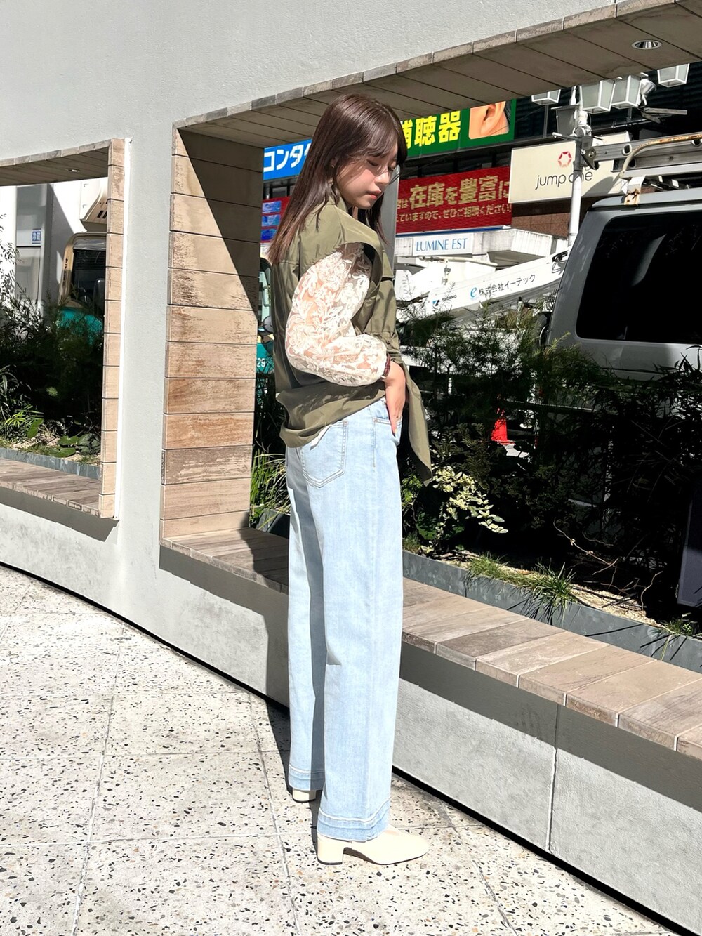 ホワイト系のシャツ/ブラウス、ホワイト系のベスト、ブルー系のデニムパンツを着用したレディースの春コーディネートの2枚目の写真