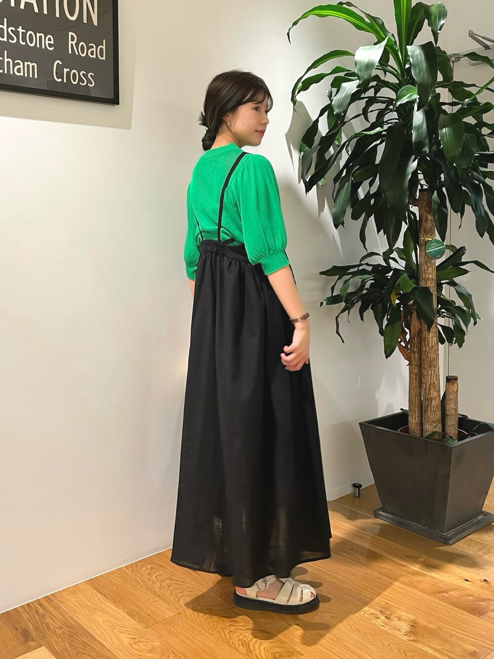 グリーン系のニット/セーター、ブラック系のワンピース、ホワイト系のサンダルを着用したレディースの夏コーディネートの3枚目の写真