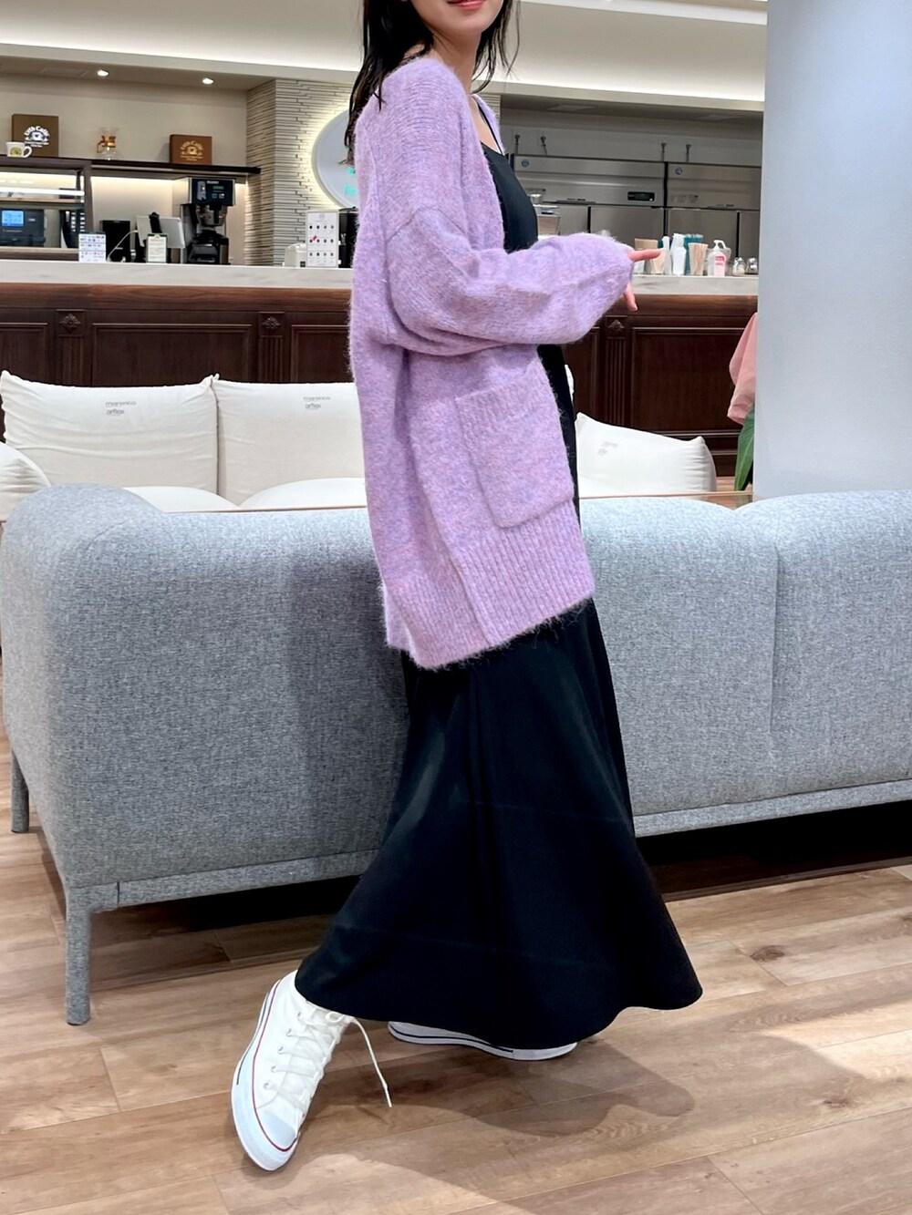 パープル系のカーディガン/ボレロ、ブラック系のワンピース、ホワイト系のスニーカーを着用したレディースの秋コーディネートの2枚目の写真