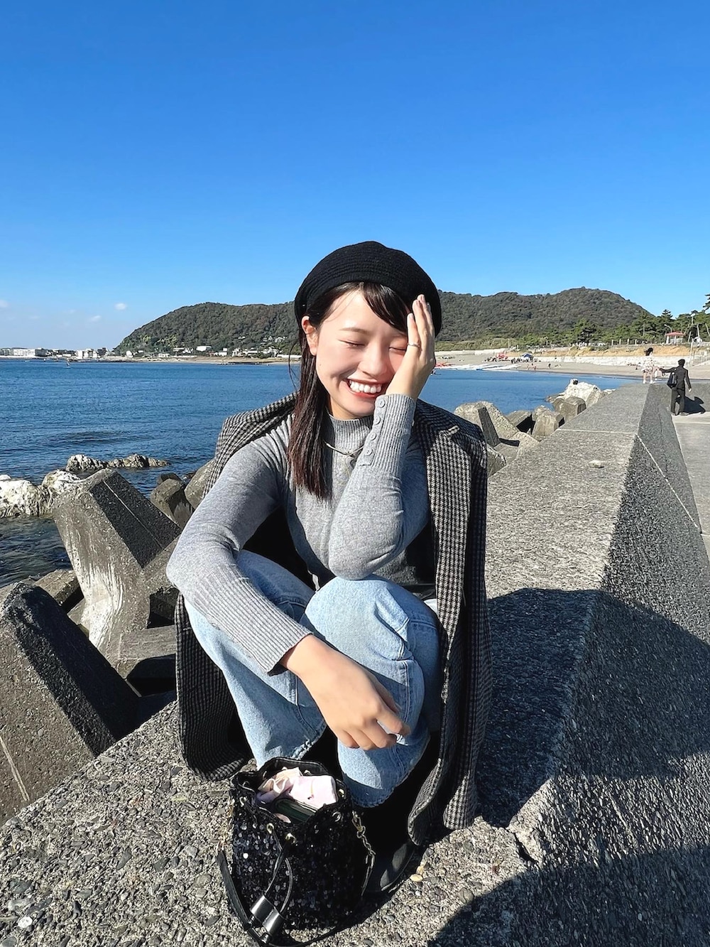 ブラック系のジャケット/アウター、ブルー系のデニムパンツ、ブラック系のハンチング/ベレー帽を着用したレディースの秋コーディネートの3枚目の写真