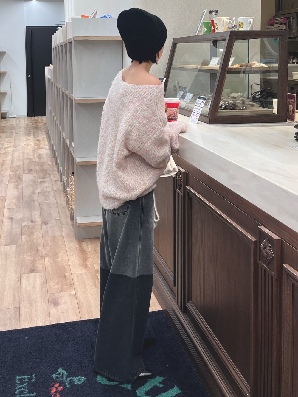 ピンク系のニット/セーター、ブラック系のデニムパンツ、ホワイト系のマフラーを着用したレディースの冬コーディネートの3枚目の写真
