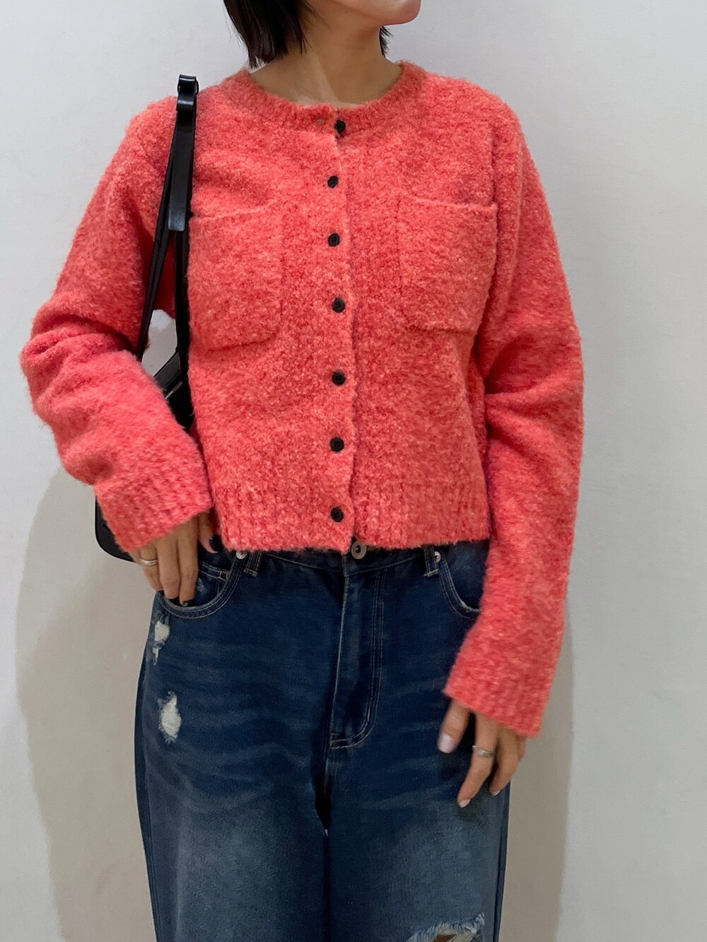 ピンク系のカーディガン/ボレロ、ブルー系のデニムパンツを着用したレディースの冬コーディネートの2枚目の写真