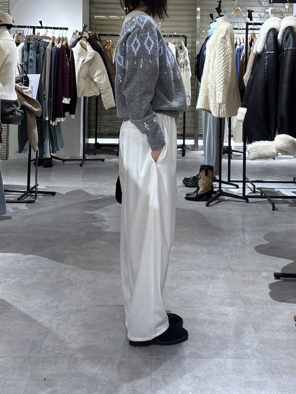 グレー系のニット/セーター、ホワイト系のその他パンツを着用したレディースの冬コーディネートの2枚目の写真