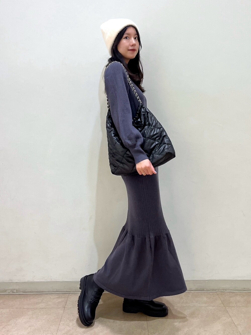 ブラック系のワンピース、ブラック系のブーツ、ブラック系のトートバッグを着用したレディースの冬コーディネートの2枚目の写真