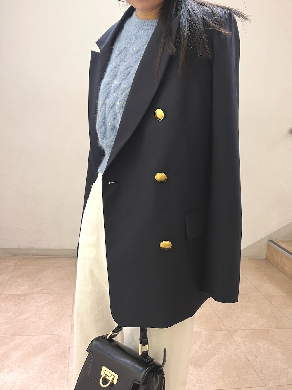 ブルー系のテーラードジャケット、ブルー系のニット/セーター、ホワイト系のデニムパンツを着用したレディースの冬コーディネートの3枚目の写真