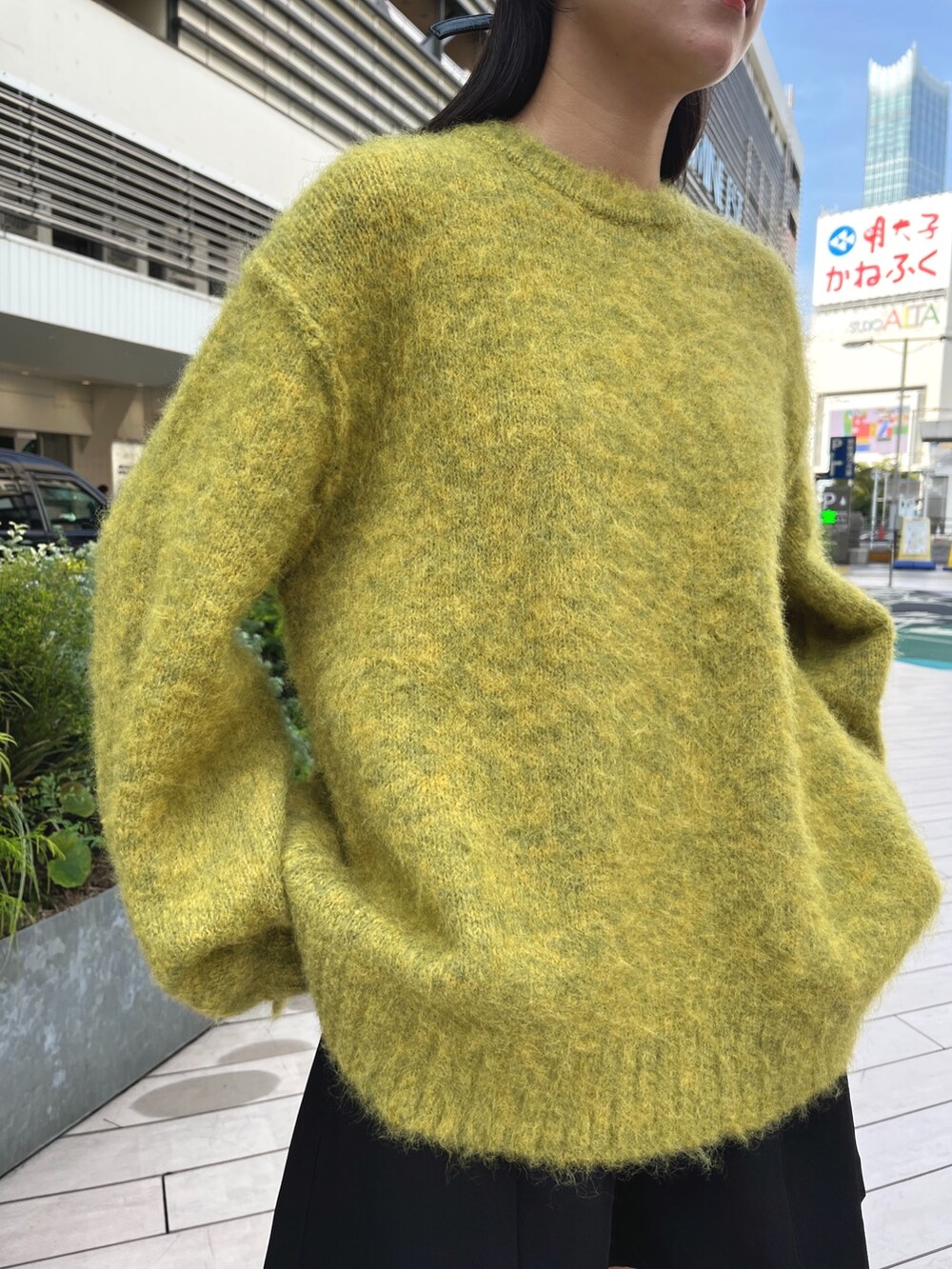 イエロー系のニット/セーター、ブラック系のその他パンツ、ホワイト系のブーツを着用したレディースの秋コーディネートの4枚目の写真