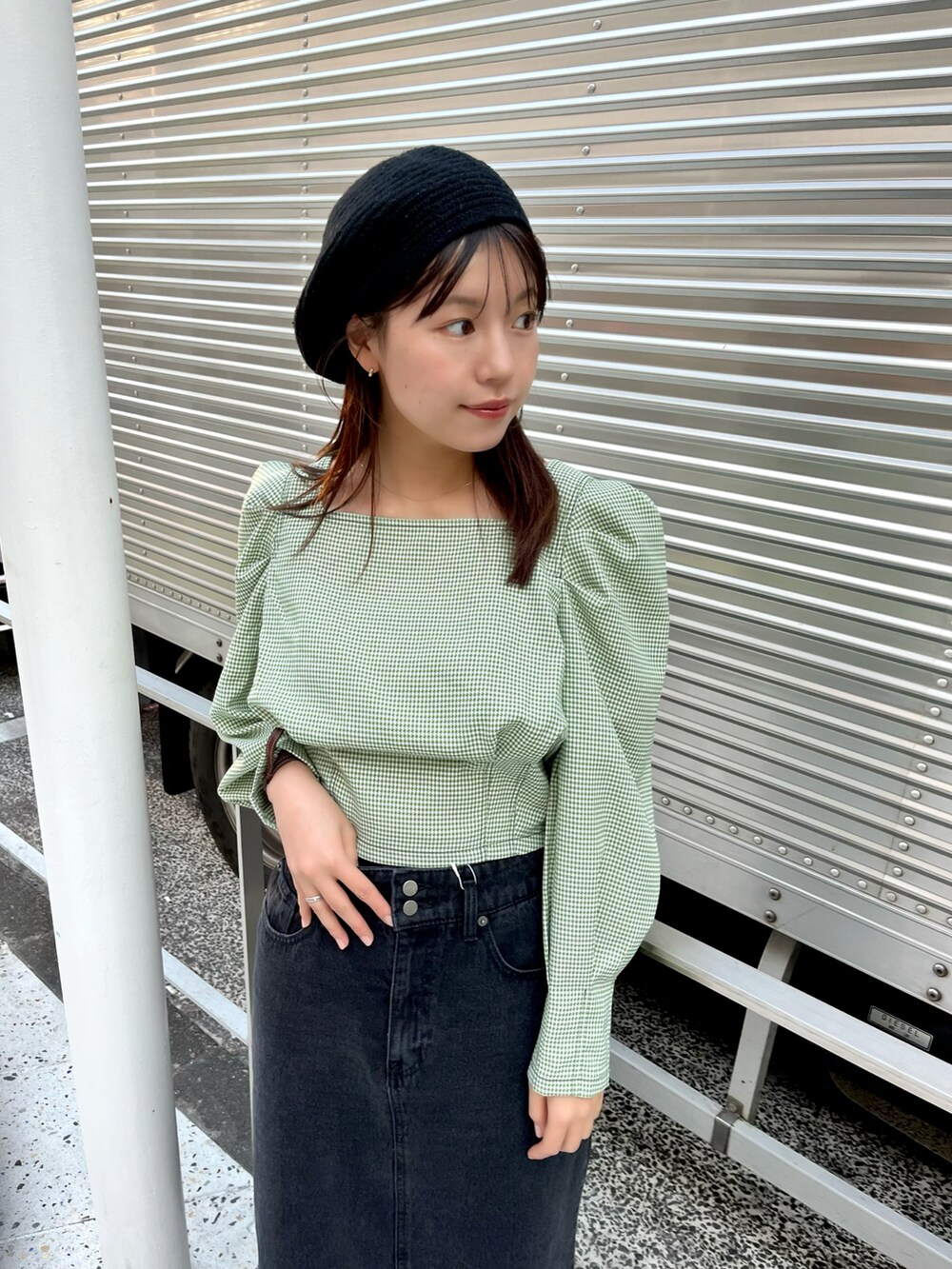 グリーン系のシャツ/ブラウス、ブラック系のスカート、ホワイト系のシューズを着用したレディースの冬コーディネートの2枚目の写真