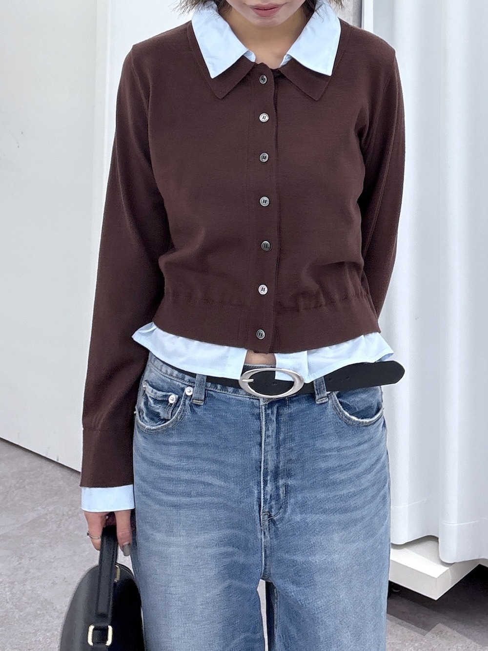 ブラウン系のニット/セーター、ブルー系のデニムパンツ、ホワイト系のトートバッグを着用したレディースの秋コーディネートの2枚目の写真