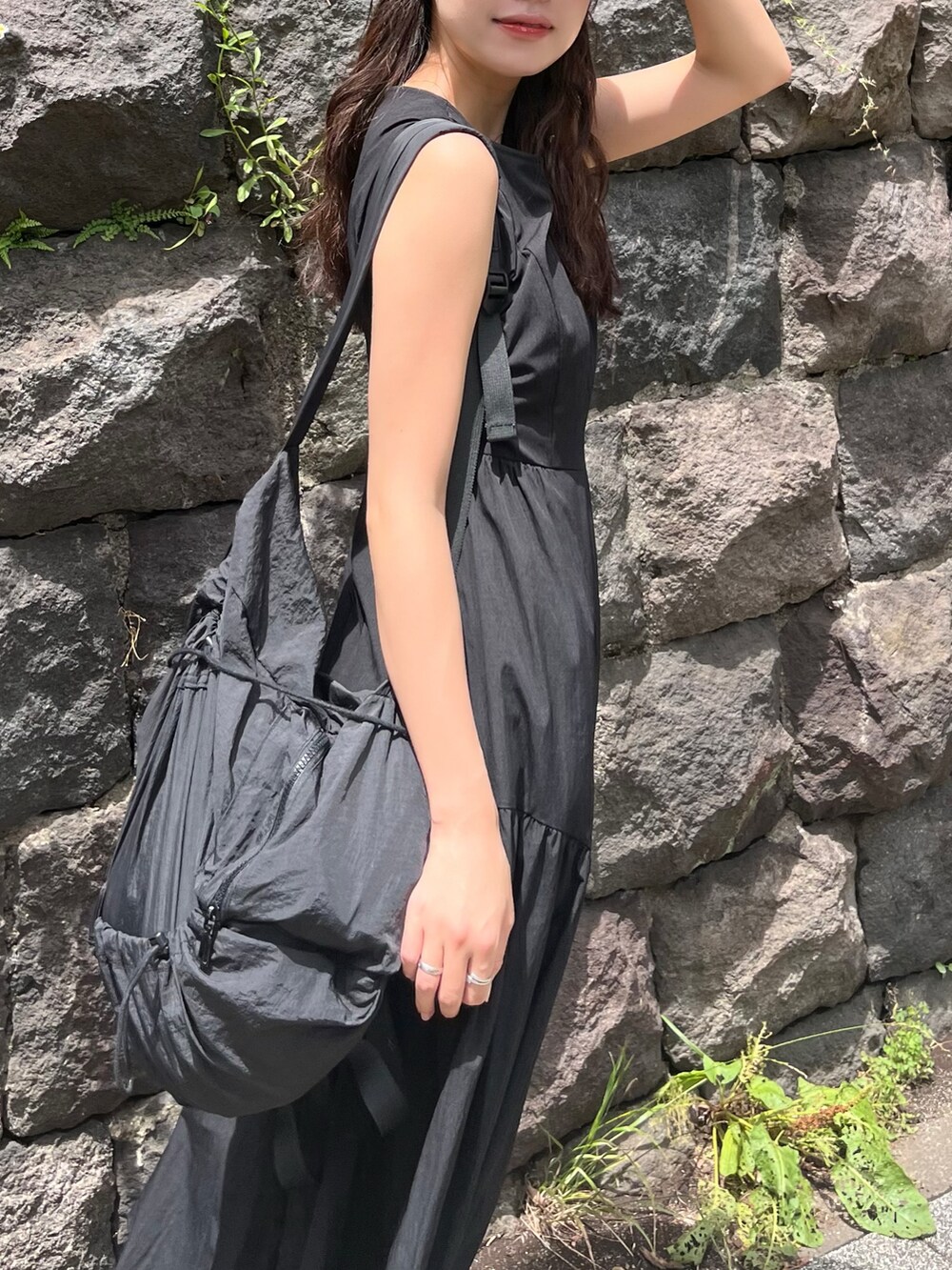 ブラック系のワンピースを着用したレディースの夏コーディネートの2枚目の写真