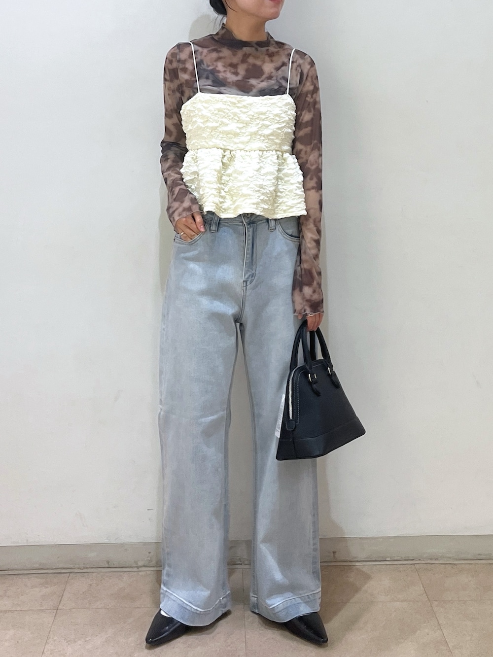 グレー系のテーラードジャケット、ブラック系のシャツ/ブラウス、ホワイト系のデニムパンツを着用したレディースの春コーディネートの2枚目の写真