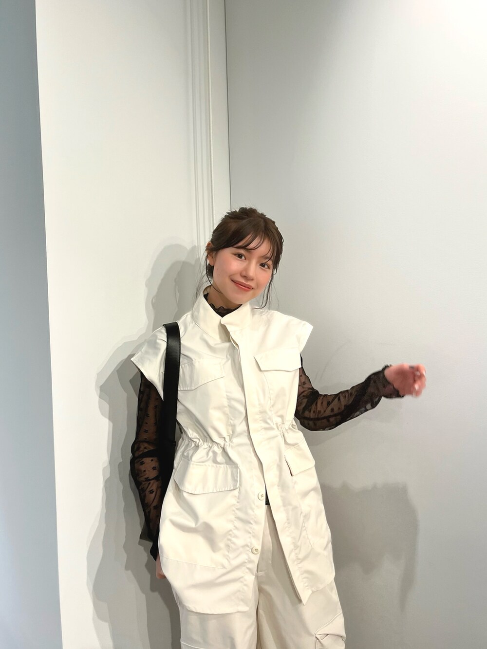 ホワイト系のベスト、ホワイト系のカーゴパンツ、ブラック系のTシャツ/カットソーを着用したレディースの春コーディネートの2枚目の写真