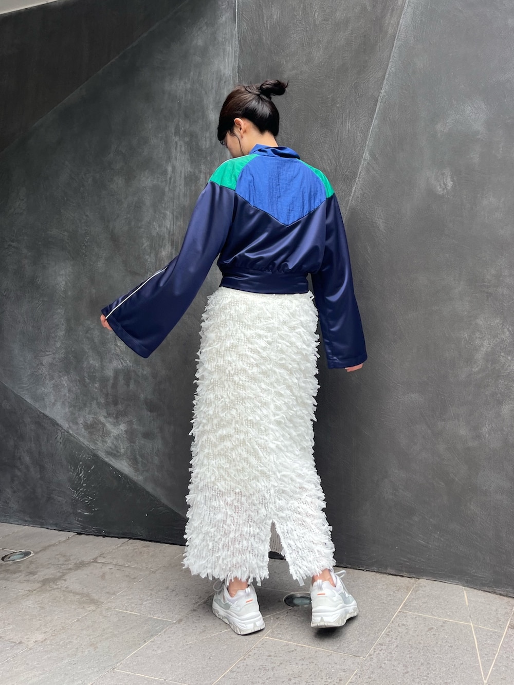 ブルー系のナイロンジャケット、ホワイト系のスカートを着用したレディースの秋コーディネートの5枚目の写真