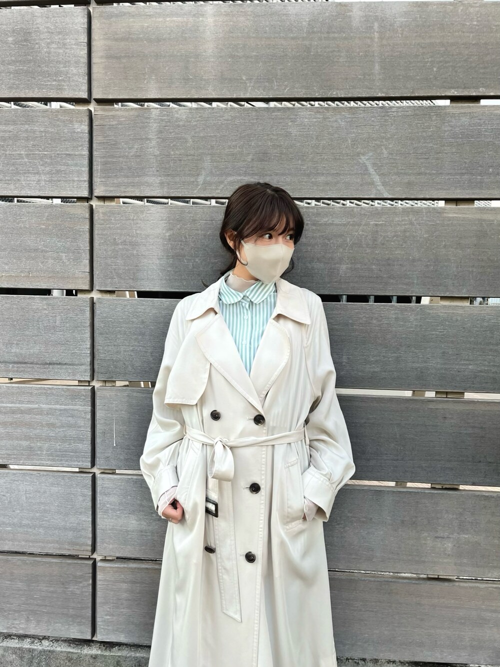 ベージュ系のトレンチコート、ブルー系のシャツ/ブラウスを着用したレディースの冬コーディネートの3枚目の写真