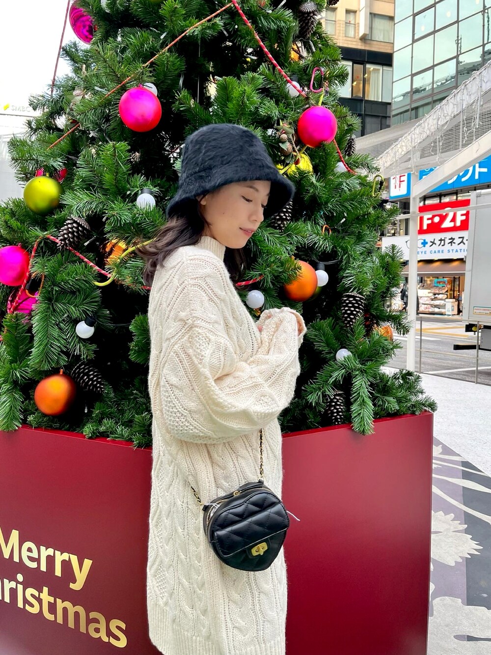 ホワイト系のワンピース、ブラック系のショルダーバッグ、ブラック系のブーツを着用したレディースの冬コーディネートの3枚目の写真