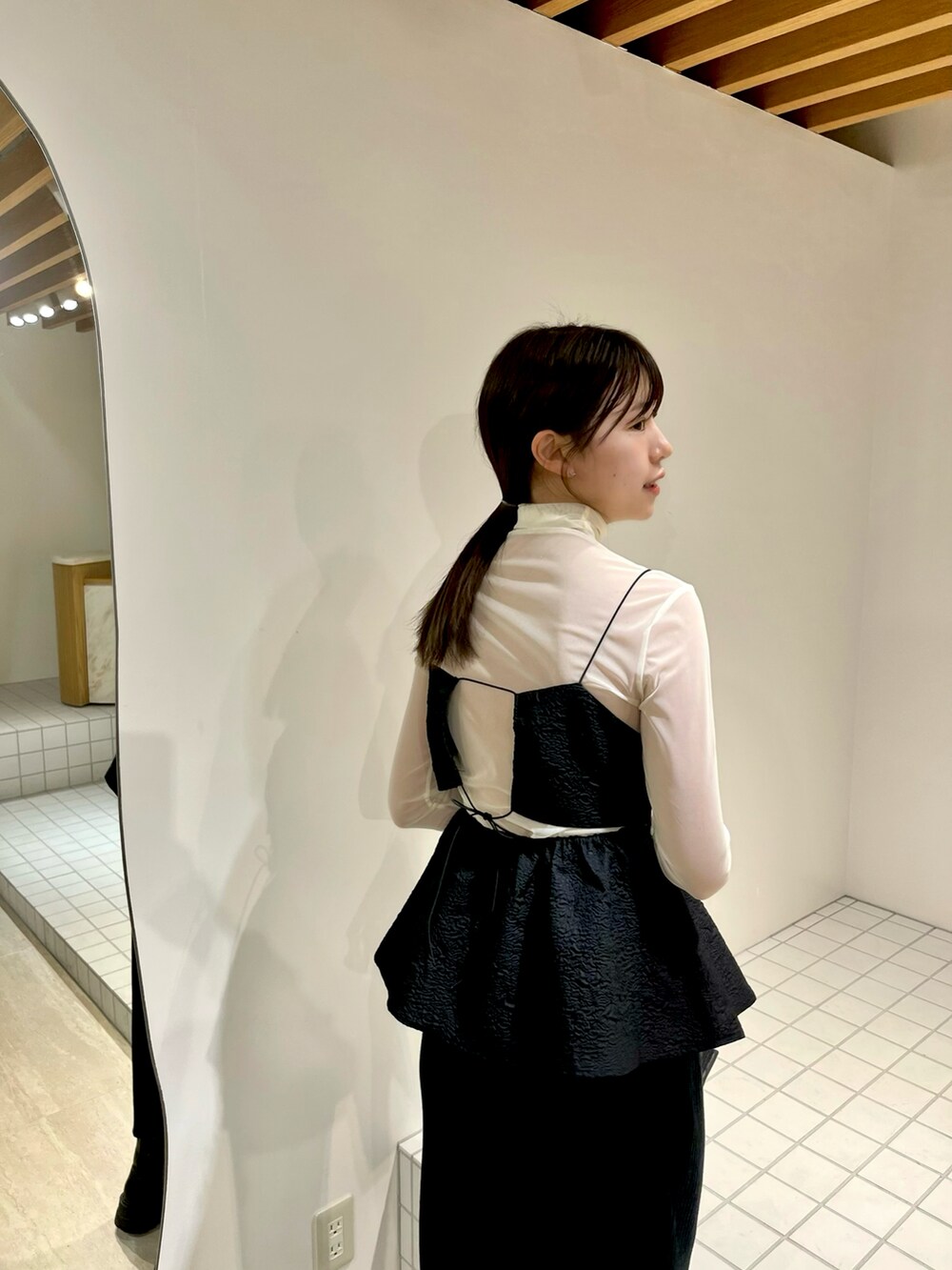 ブラック系のシャツ/ブラウス、ホワイト系のTシャツ/カットソー、ブラック系のスカートを着用したレディースの冬コーディネートの2枚目の写真