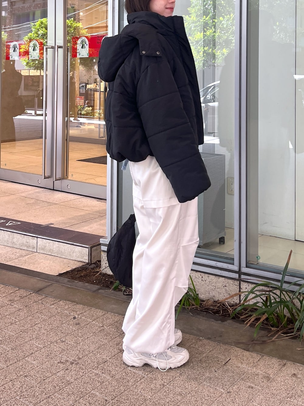 ブラック系のブルゾン、ブルー系のニット/セーター、ホワイト系のカーゴパンツを着用したレディースの冬コーディネートの2枚目の写真