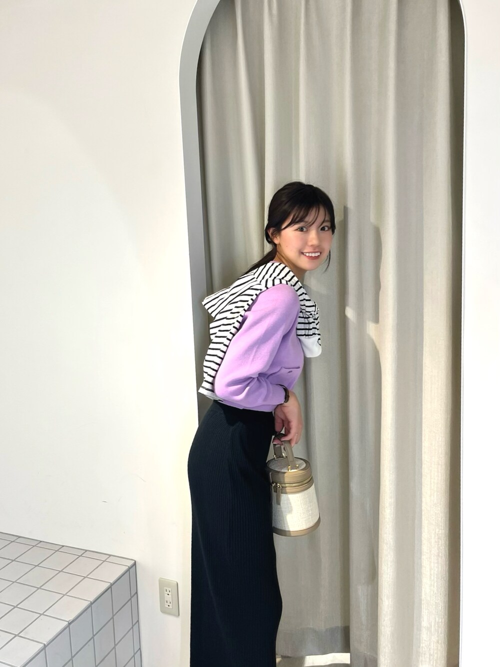 パープル系のカーディガン/ボレロ、ブラック系のスカート、ブラック系のTシャツ/カットソーを着用したレディースの冬コーディネートの2枚目の写真