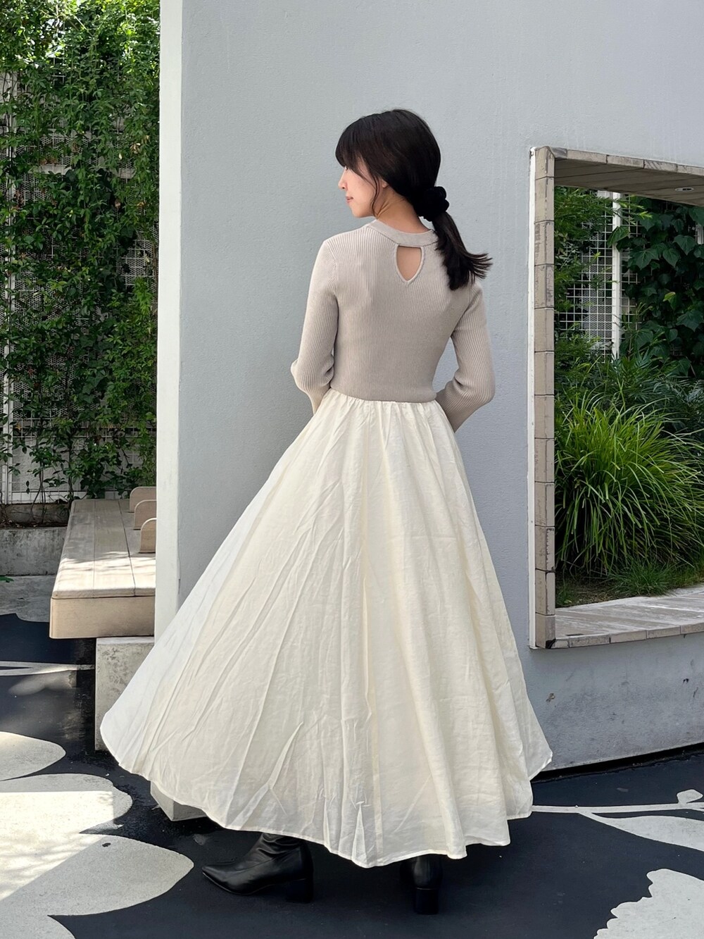 ホワイト系のワンピース、ブラック系のブーツを着用したレディースの秋コーディネートの2枚目の写真