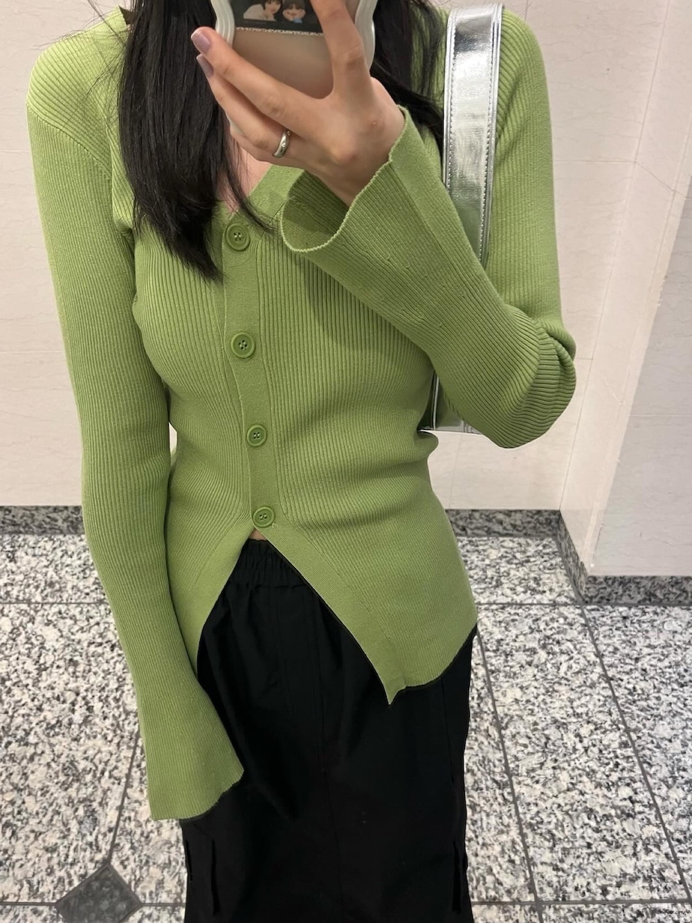 グリーン系のカーディガン/ボレロ、ブラック系のスカート、ホワイト系のスニーカーを着用したレディースの冬コーディネートの3枚目の写真