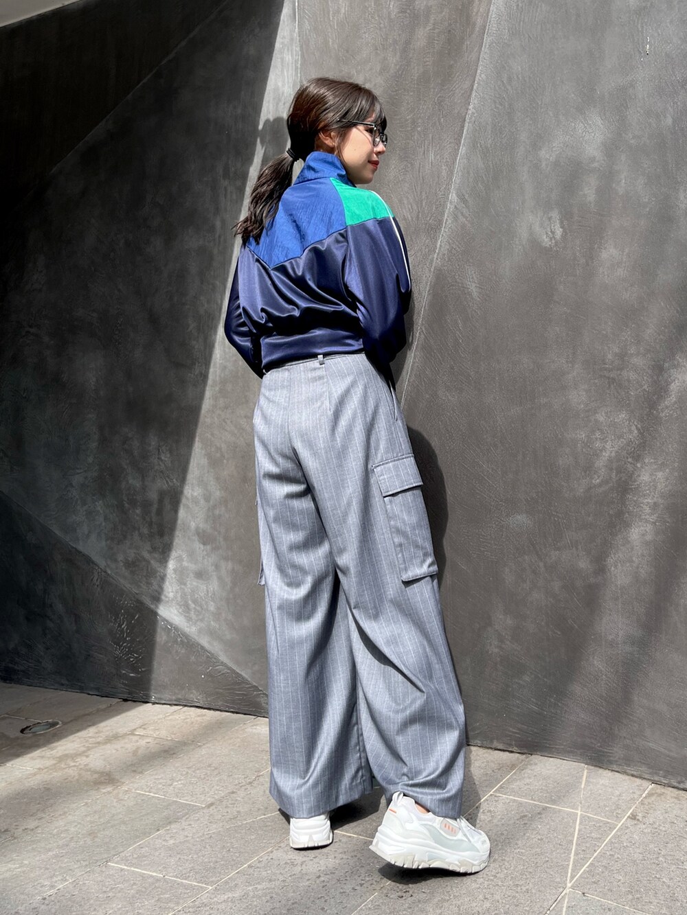 ブルー系のナイロンジャケット、グレー系のスラックスを着用したレディースの秋コーディネートの3枚目の写真