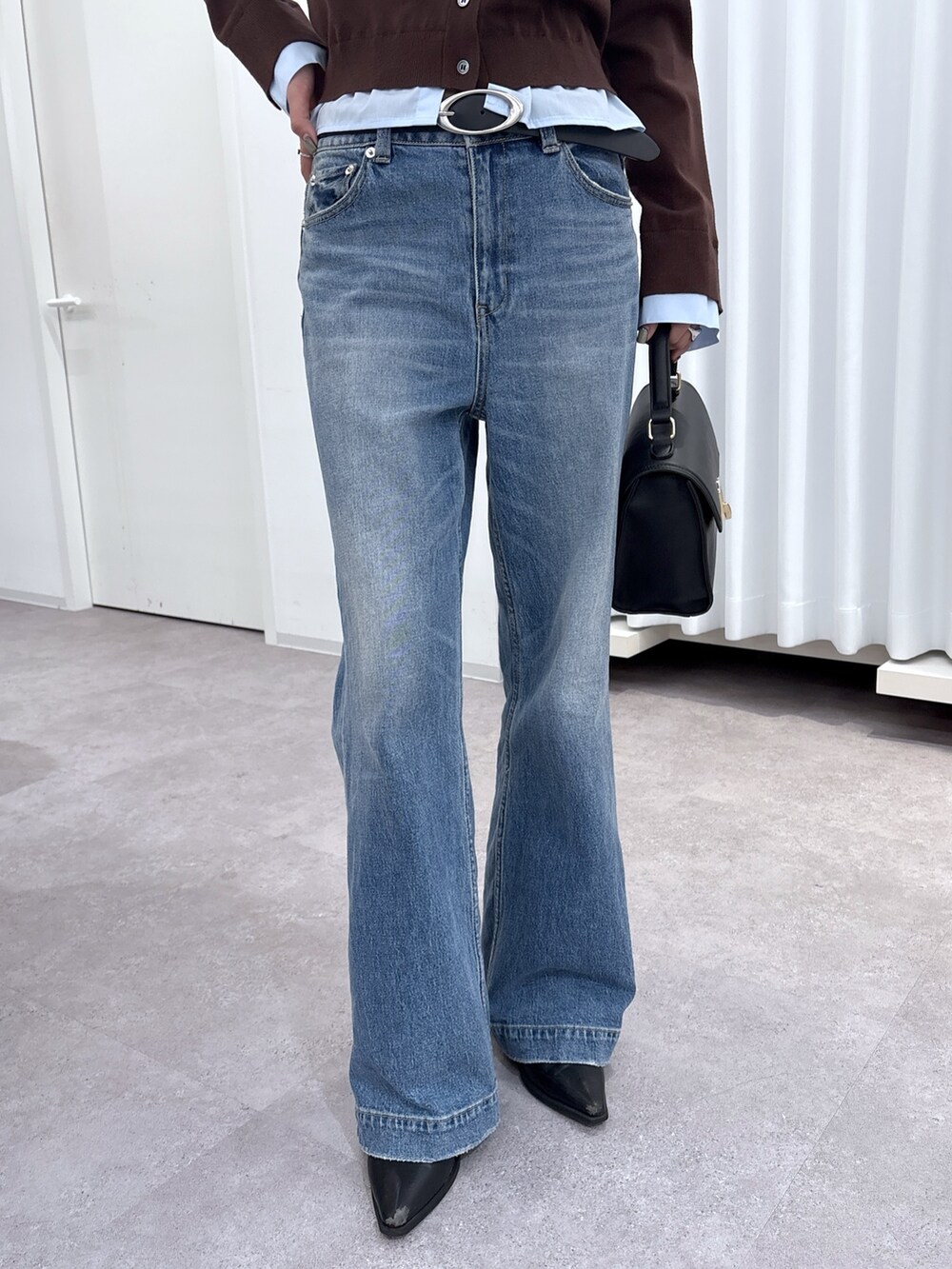 ブラウン系のニット/セーター、ブルー系のデニムパンツ、ホワイト系のトートバッグを着用したレディースの秋コーディネートの3枚目の写真