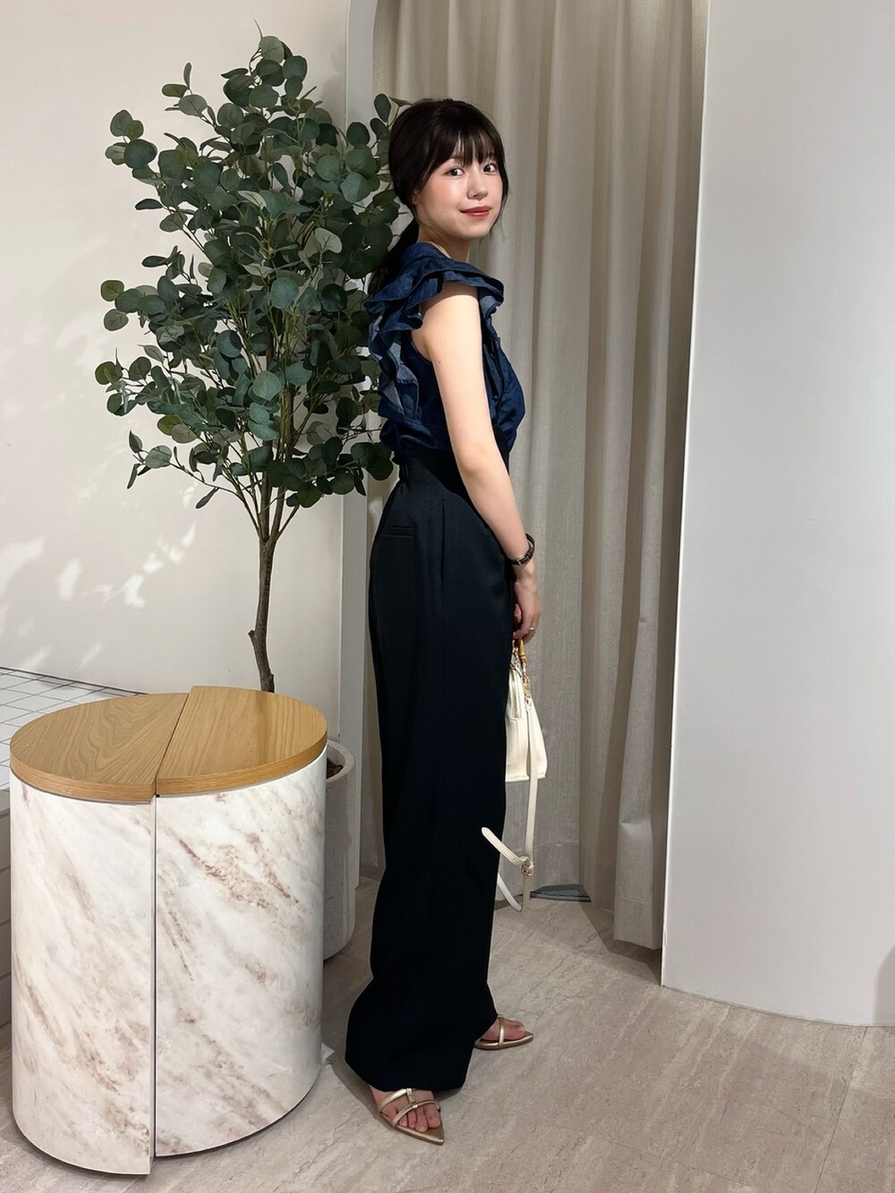 ブルー系のシャツ/ブラウス、ブラック系のサロペット/オーバーオール、ゴールド系のサンダルを着用したレディースの夏コーディネートの2枚目の写真