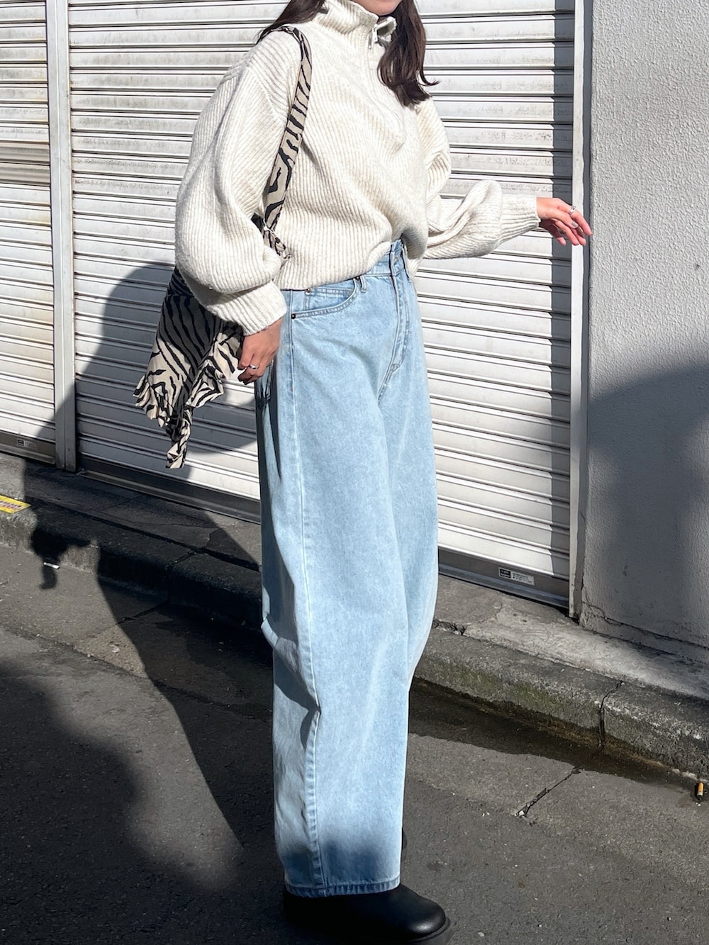 ホワイト系のワンピース、ブルー系のデニムパンツ、ベージュ系のトートバッグを着用したレディースの秋コーディネートの2枚目の写真