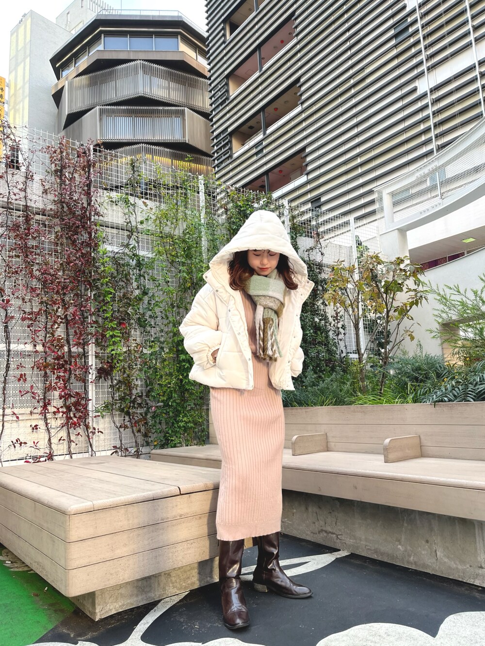 ホワイト系のブルゾン、ベージュ系のワンピース、グリーン系のストール/ショールを着用したレディースの冬コーディネートの3枚目の写真