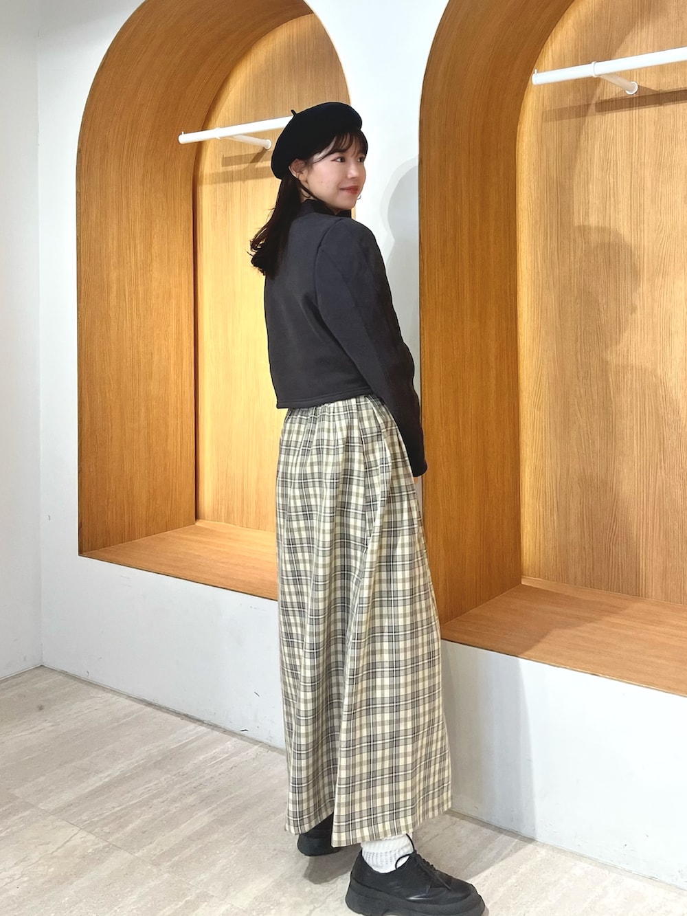 ブラック系のTシャツ/カットソー、ベージュ系のスカート、ブラック系のハンチング/ベレー帽を着用したレディースの冬コーディネートの2枚目の写真