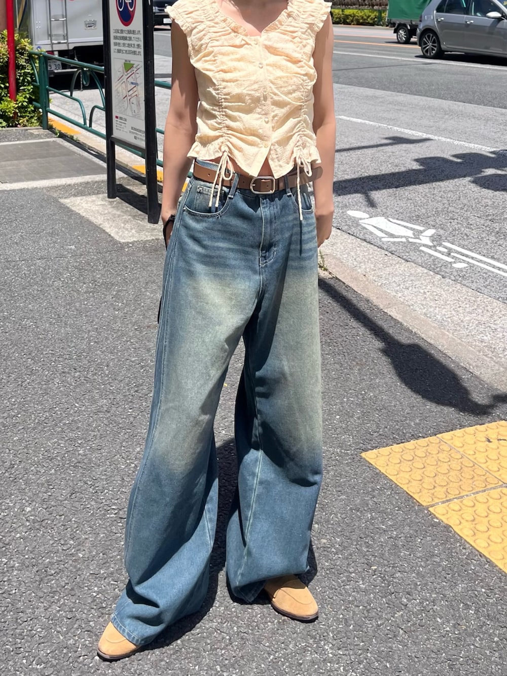 イエロー系のシャツ/ブラウス、ブルー系のデニムパンツを着用したレディースの春コーディネートの2枚目の写真