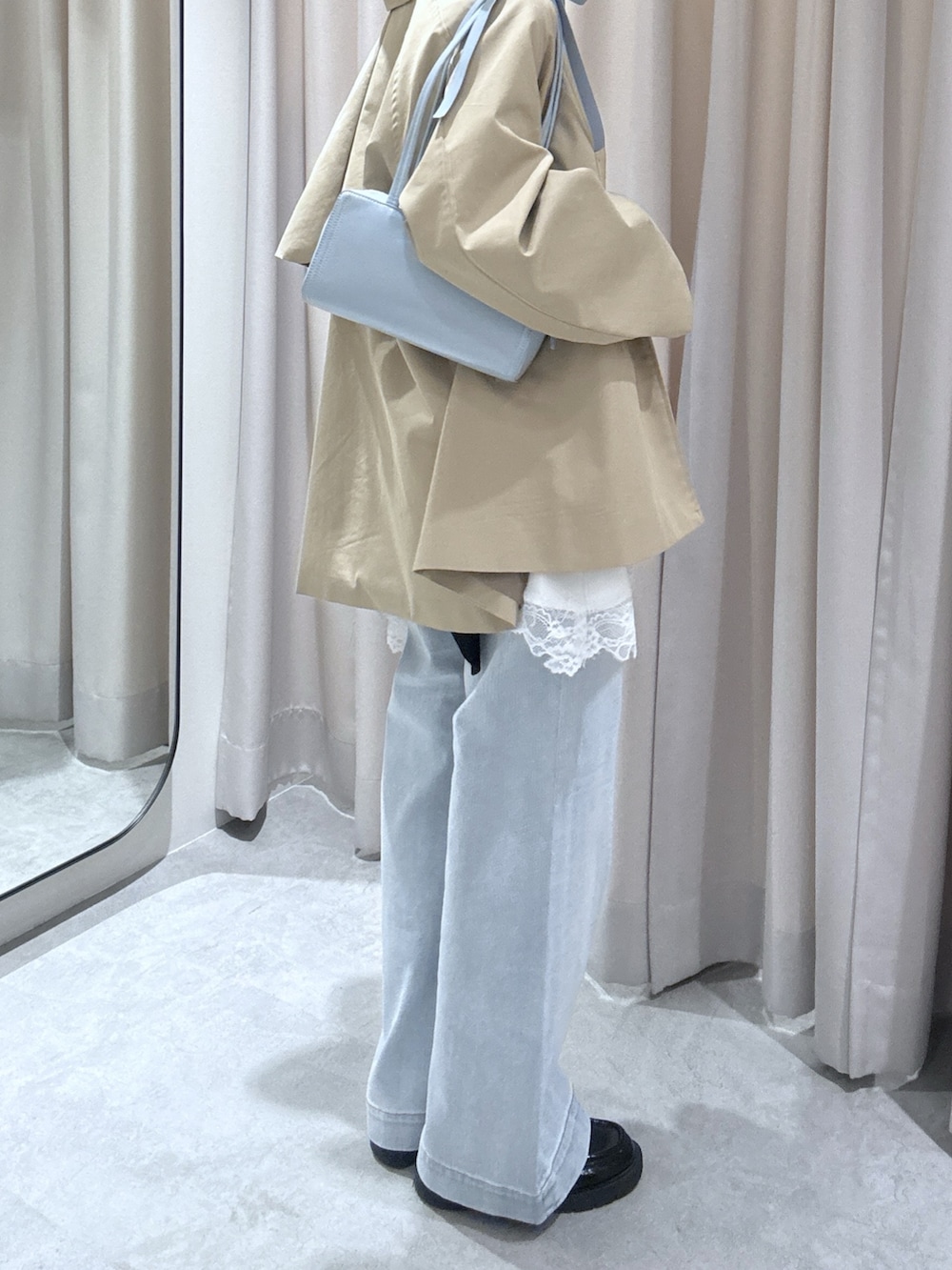 ホワイト系のワンピース、ブルー系のデニムパンツを着用したレディースの春コーディネートの2枚目の写真