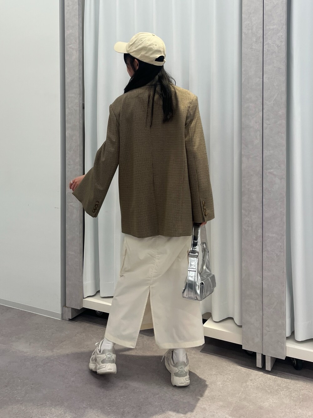 ブラウン系のテーラードジャケット、ブラック系のスカート、ホワイト系のスニーカーを着用したレディースの冬コーディネートの3枚目の写真