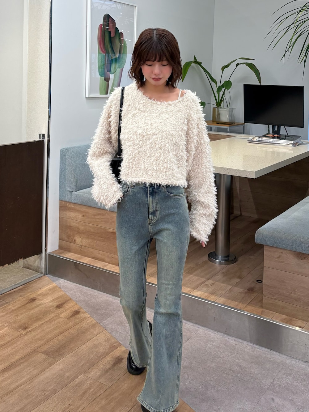 ホワイト系のスウェット、ホワイト系のデニムパンツを着用したレディースの秋コーディネートの2枚目の写真