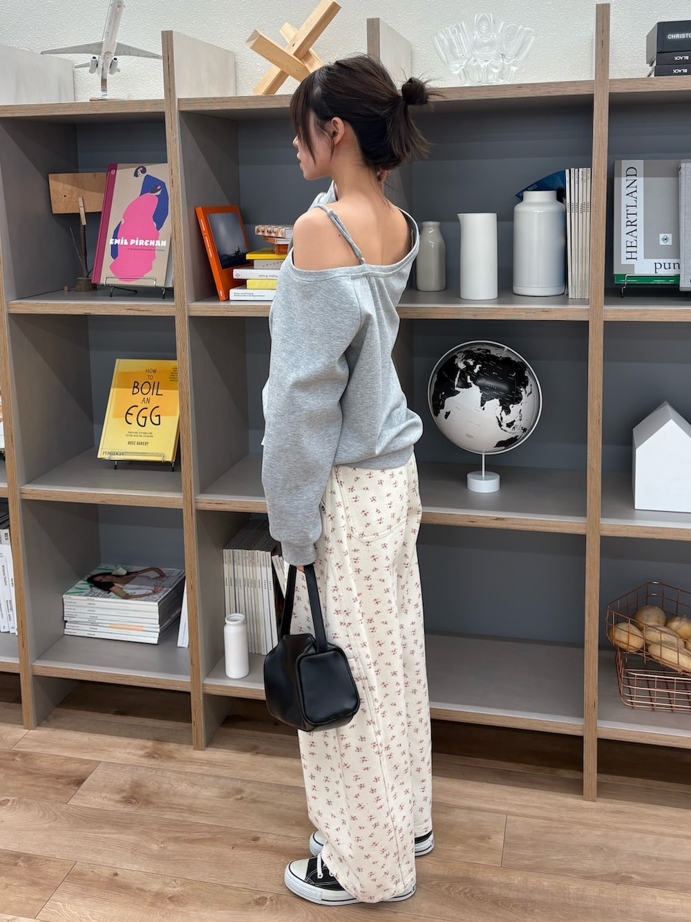 グレー系のスウェット、ホワイト系のデニムパンツを着用したレディースの冬コーディネートの2枚目の写真