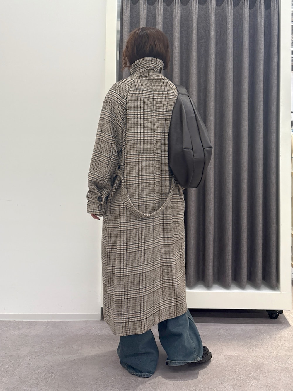 ブラウン系のステンカラーコートを着用したレディースの冬コーディネートの3枚目の写真