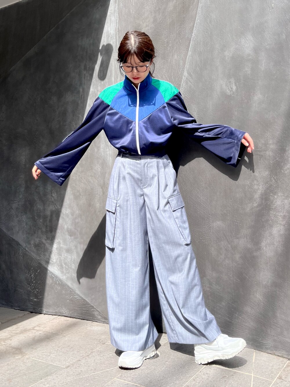 ブルー系のナイロンジャケット、グレー系のスラックスを着用したレディースの秋コーディネートの2枚目の写真