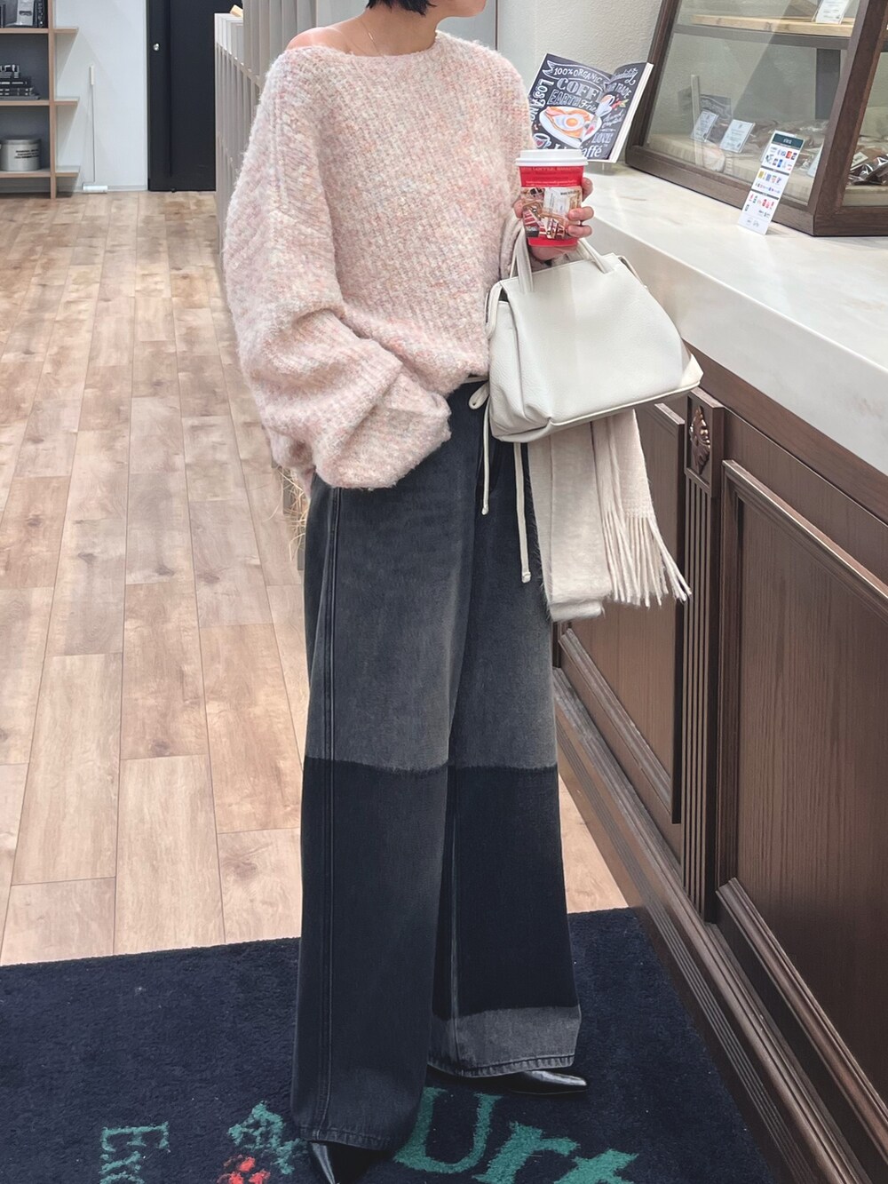ピンク系のニット/セーター、ブラック系のデニムパンツ、ホワイト系のマフラーを着用したレディースの冬コーディネートの4枚目の写真