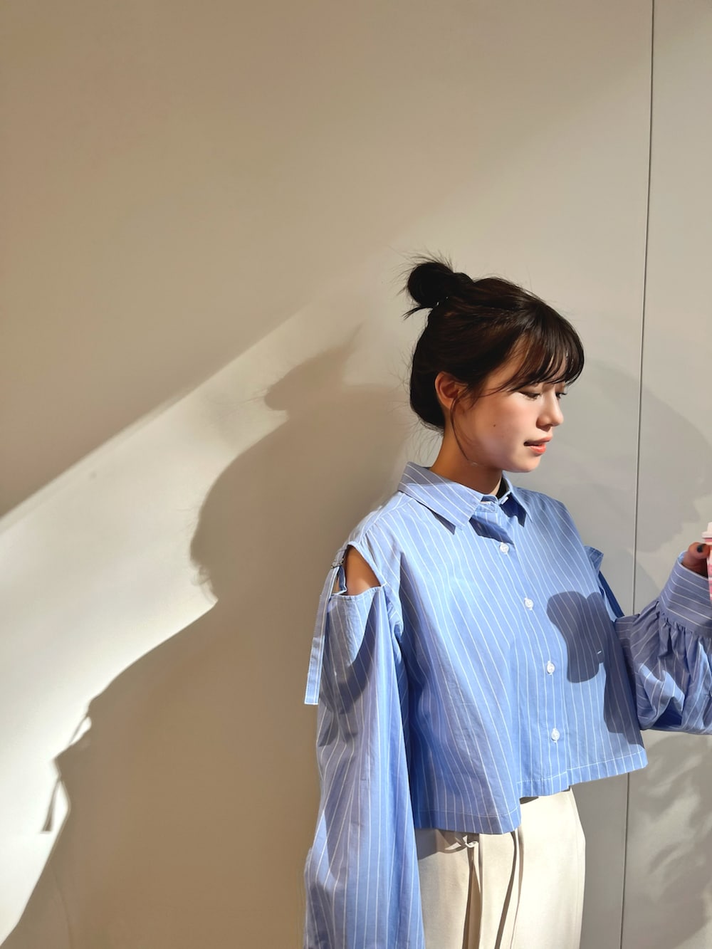 ブルー系のシャツ/ブラウス、ベージュ系のスカート、ホワイト系のスニーカーを着用したレディースの春コーディネートの3枚目の写真