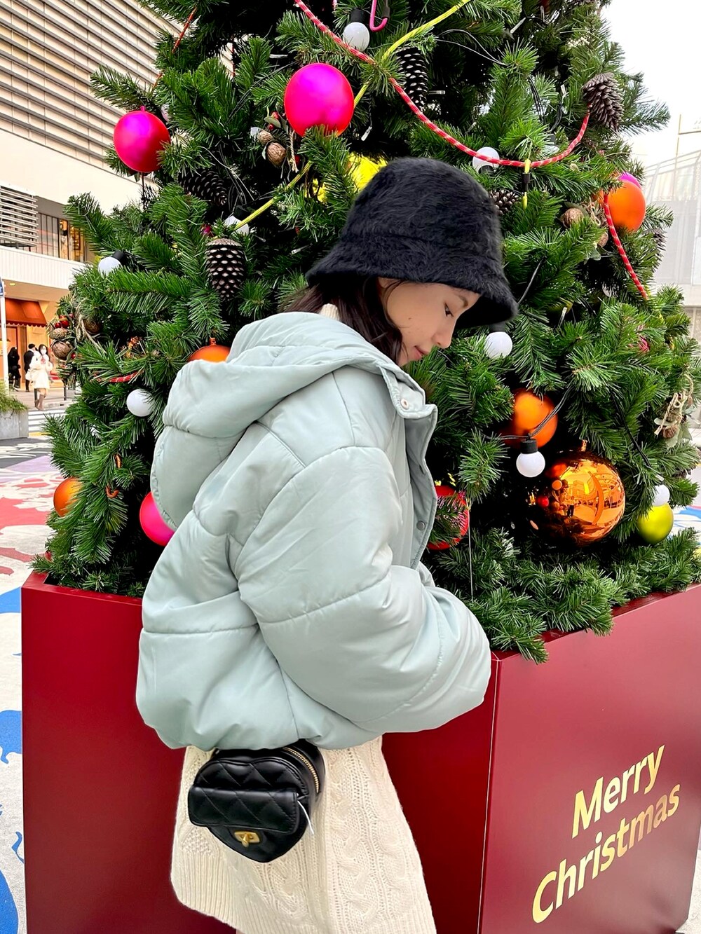 ホワイト系のワンピース、ブラック系のショルダーバッグ、ブラック系のブーツを着用したレディースの冬コーディネートの5枚目の写真