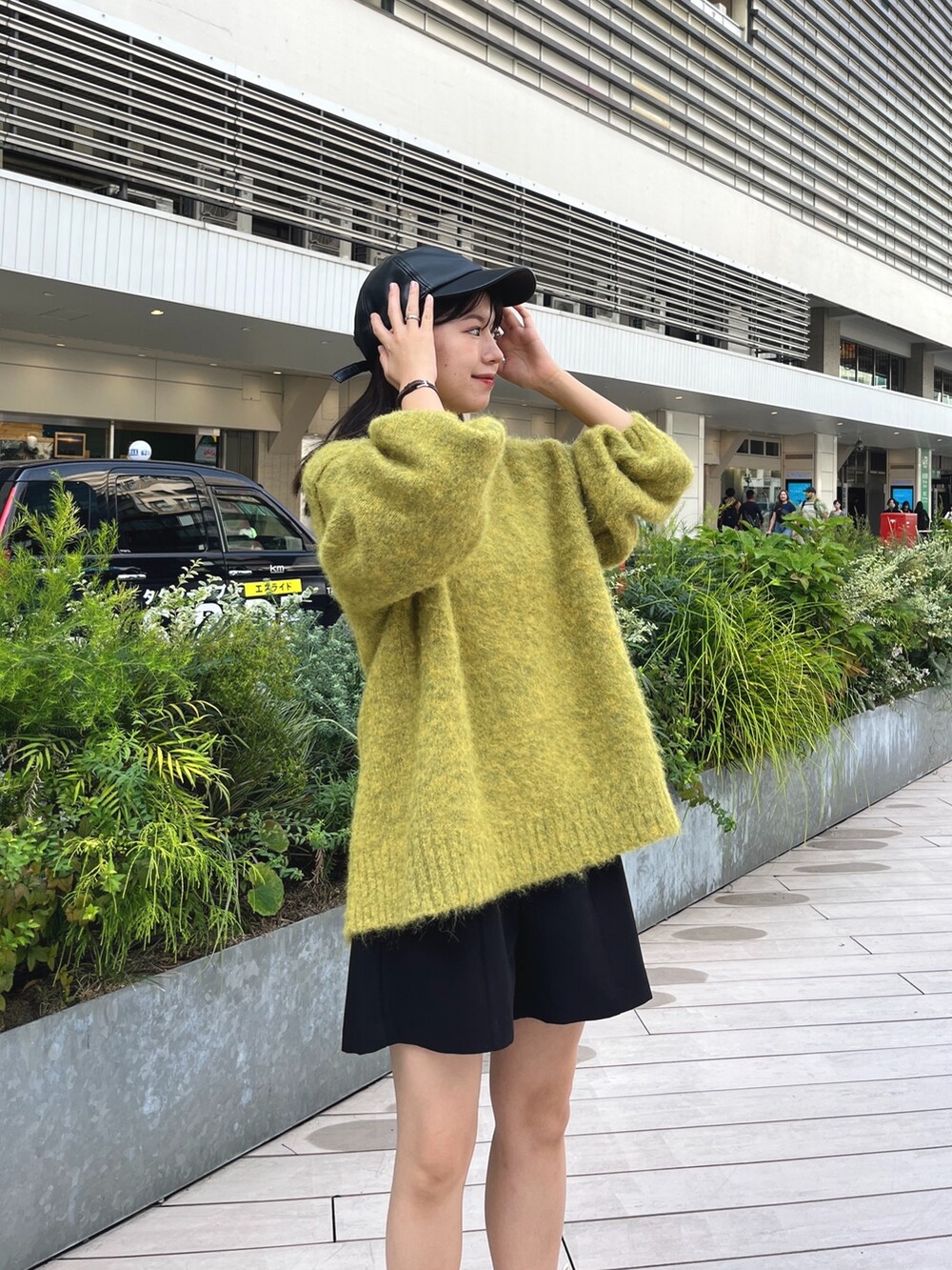 イエロー系のニット/セーター、ブラック系のその他パンツ、ホワイト系のブーツを着用したレディースの秋コーディネートの3枚目の写真
