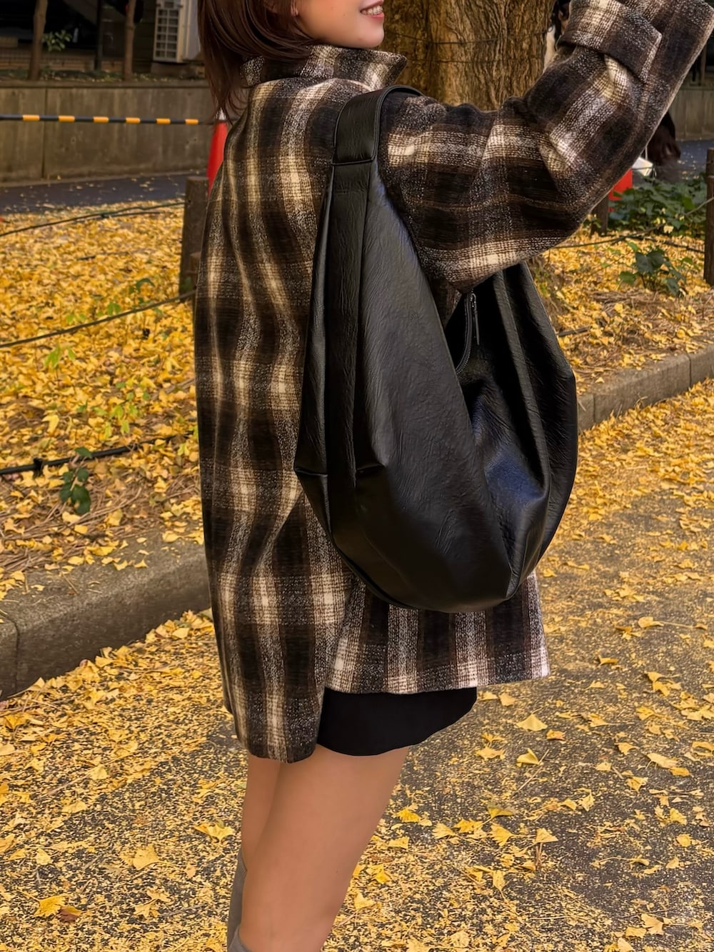 ブラウン系のピーコートを着用したレディースの秋コーディネートの3枚目の写真